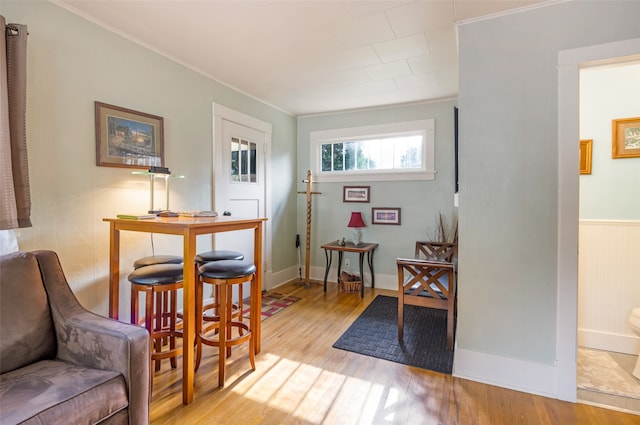 living area featuring crown molding and light wood-type flooring