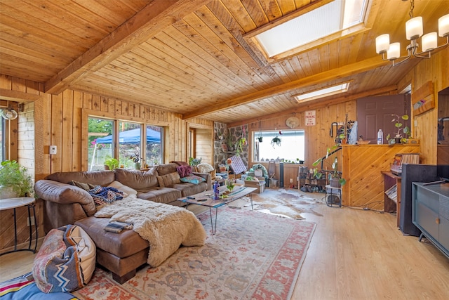 living room featuring light hardwood / wood-style floors, lofted ceiling with skylight, wooden walls, and wood ceiling