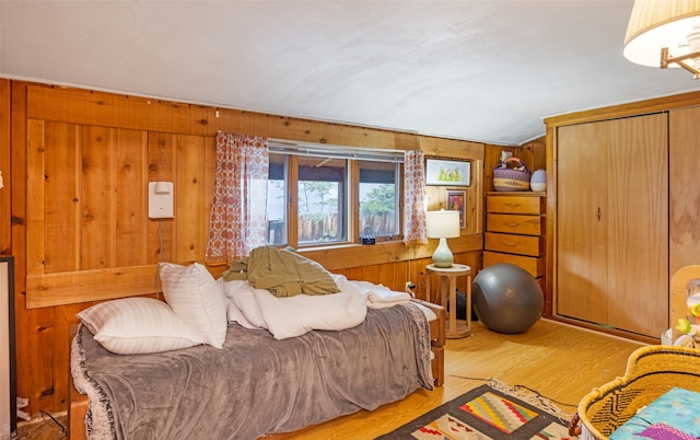 bedroom featuring wood walls and light hardwood / wood-style floors