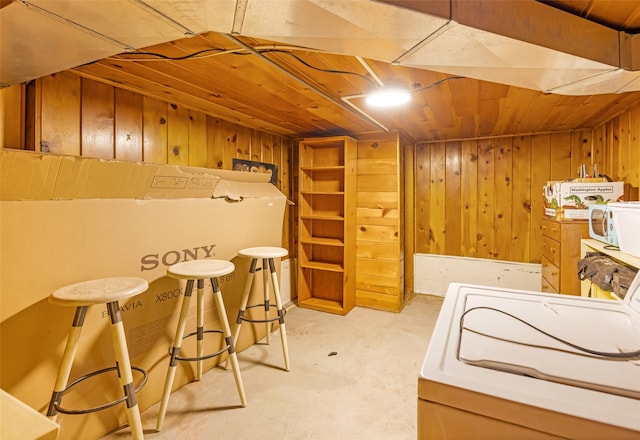 bedroom featuring wood walls and washer / clothes dryer