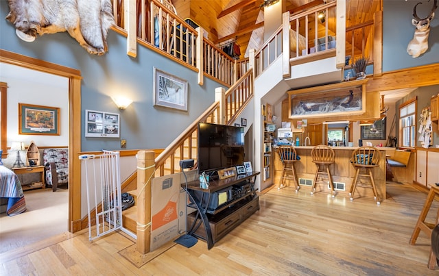 interior space with beam ceiling, wooden ceiling, light hardwood / wood-style flooring, and a high ceiling