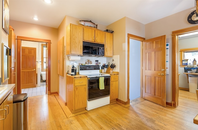 kitchen with electric stove and light hardwood / wood-style floors