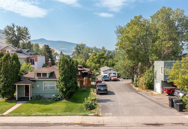 view of front of property featuring a mountain view, a garage, and a front lawn