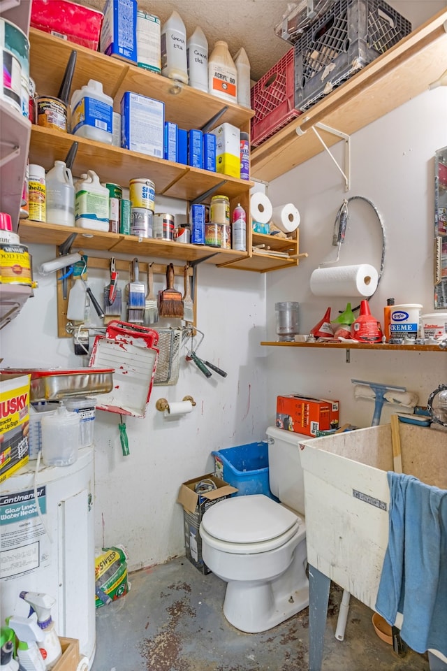 bathroom featuring concrete floors and toilet