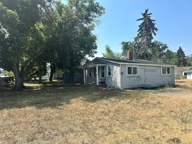 rear view of property with a yard