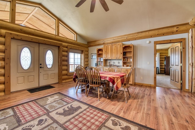 dining room with light wood finished floors, baseboards, high vaulted ceiling, and ceiling fan