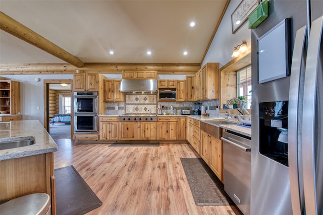 kitchen with decorative backsplash, light wood-style flooring, light stone countertops, stainless steel appliances, and under cabinet range hood