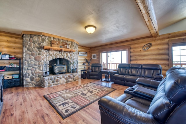 living room featuring beam ceiling, log walls, a textured ceiling, and wood finished floors