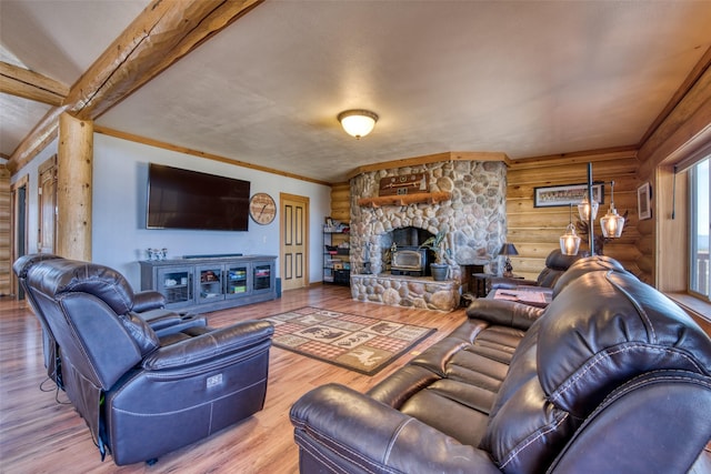 living room with ornamental molding, a wood stove, log walls, and wood finished floors