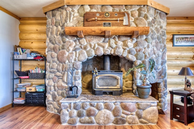 interior details with a wood stove, log walls, and wood finished floors