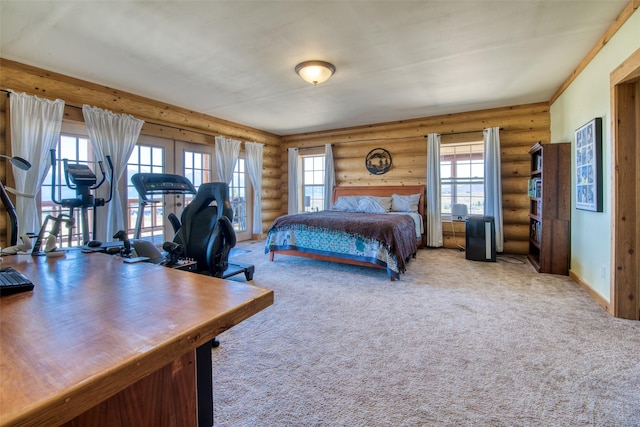 carpeted bedroom featuring rustic walls, multiple windows, and baseboards