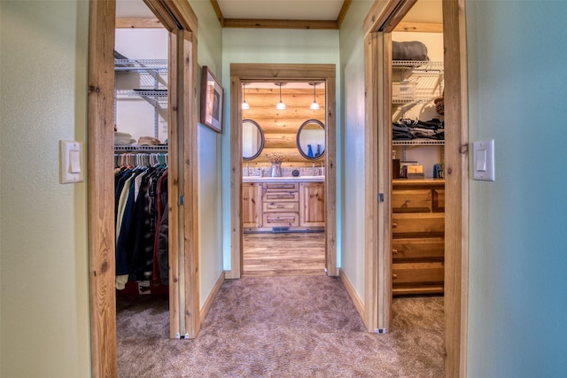 corridor with carpet, rustic walls, and baseboards