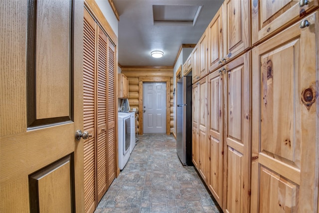 laundry area with stone finish flooring, cabinet space, log walls, and separate washer and dryer