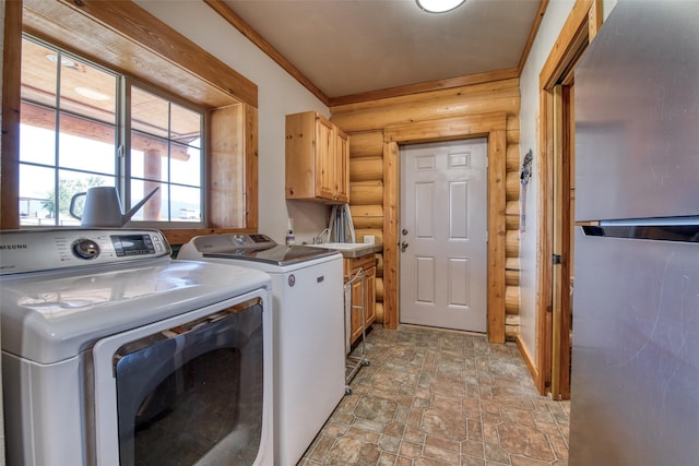 washroom featuring rustic walls, cabinet space, stone finish flooring, and washer and dryer