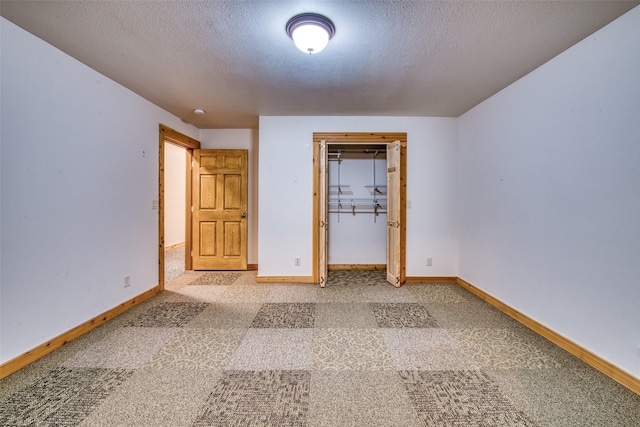 carpeted spare room with baseboards and a textured ceiling