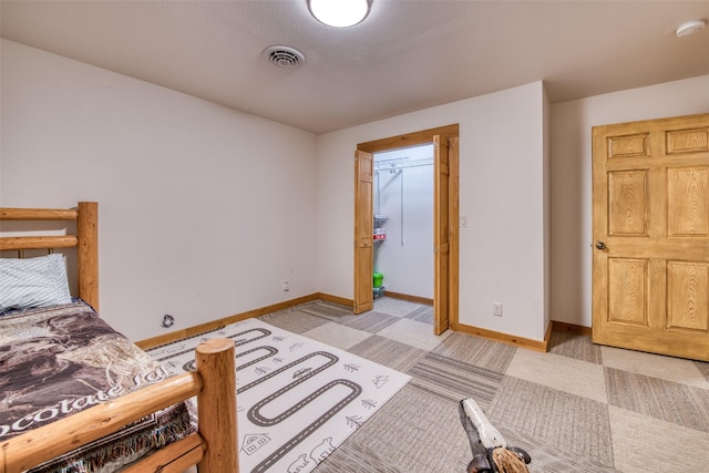 bedroom with visible vents, light carpet, and baseboards