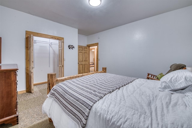 carpeted bedroom with a closet and baseboards