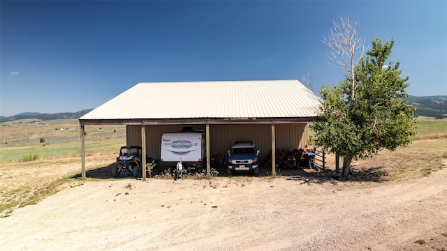 detached garage with a mountain view and a carport