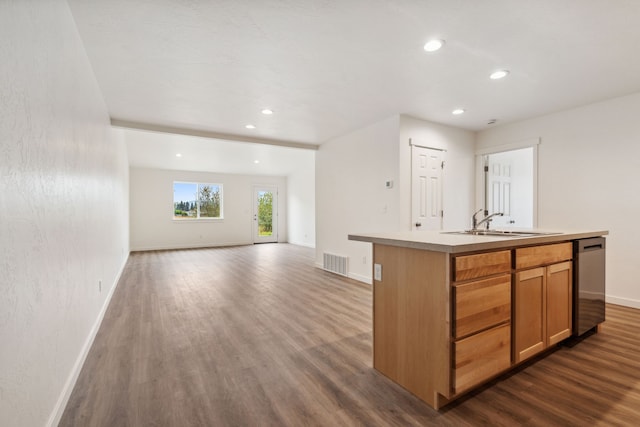 kitchen featuring dark wood-type flooring, sink, a kitchen island with sink, and stainless steel dishwasher