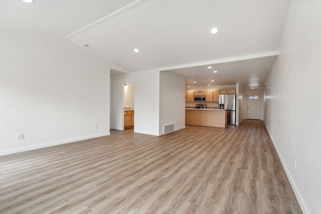 unfurnished living room with vaulted ceiling and light hardwood / wood-style floors