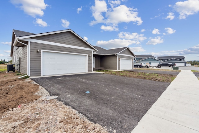 single story home with a garage and central air condition unit