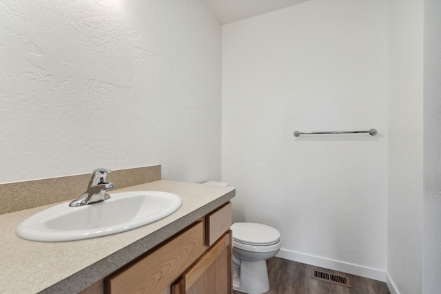 bathroom featuring hardwood / wood-style flooring, vanity, and toilet