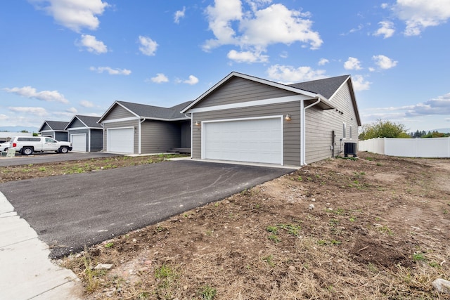 ranch-style house featuring central air condition unit and a garage