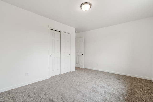 unfurnished bedroom featuring carpet floors and a closet