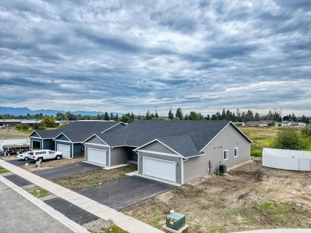 view of front facade with central AC unit, a mountain view, and a garage