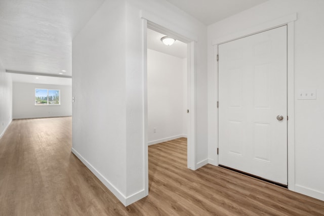 hallway with light hardwood / wood-style floors