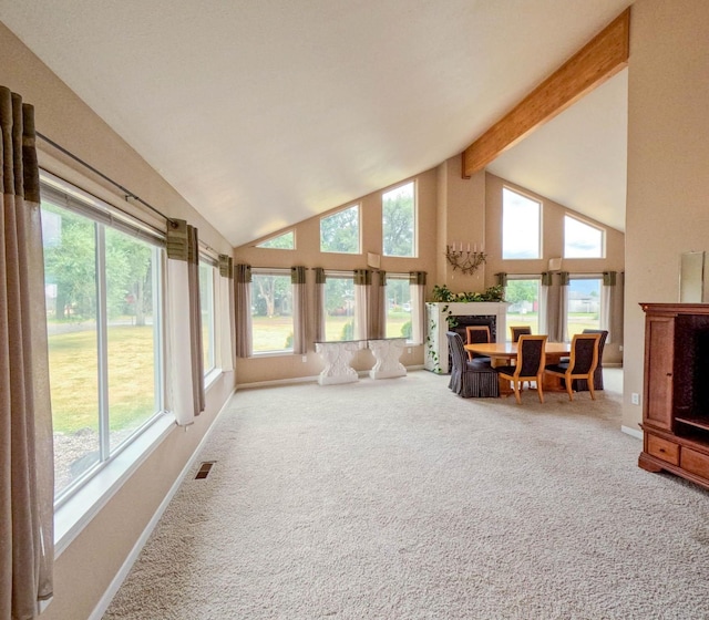 interior space featuring beam ceiling, a wealth of natural light, high vaulted ceiling, and carpet