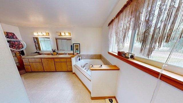 bathroom with a bathing tub, vanity, and tile patterned floors