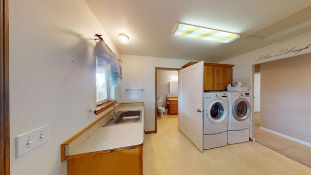 washroom with sink, cabinets, and washing machine and clothes dryer