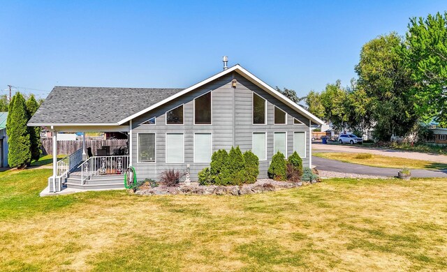 back of house with covered porch and a lawn