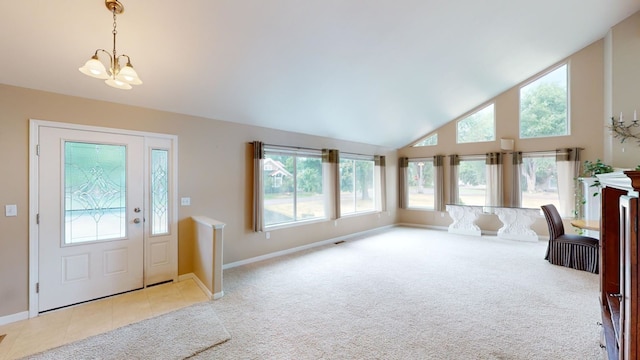 carpeted foyer entrance with high vaulted ceiling and a chandelier