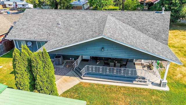 rear view of property with a wooden deck, cooling unit, and a lawn