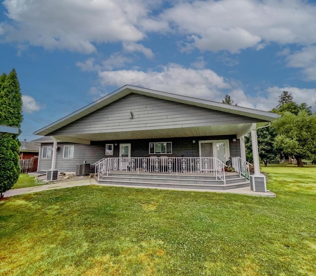 rear view of house with a yard, cooling unit, and covered porch