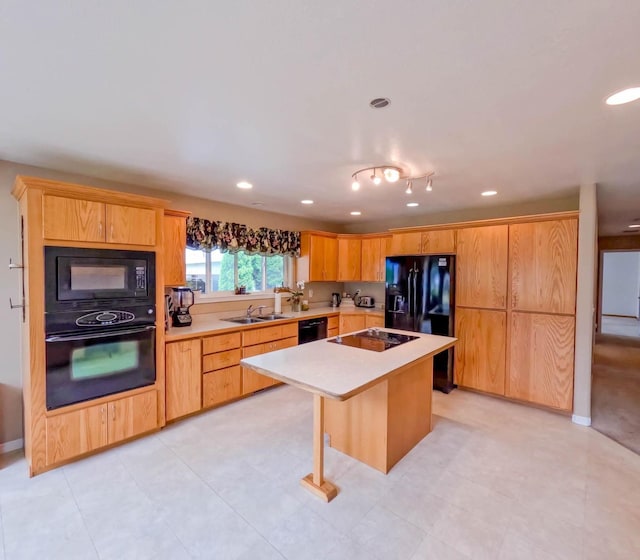 kitchen with sink, a kitchen breakfast bar, a center island, black appliances, and light brown cabinets