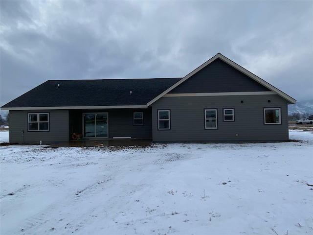 view of snow covered rear of property