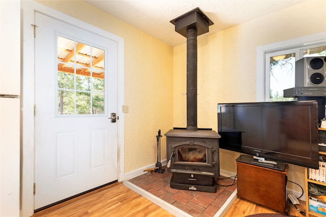 interior space with a wood stove and light wood-type flooring