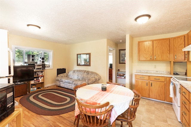 interior space with electric range, a textured ceiling, and light tile patterned floors