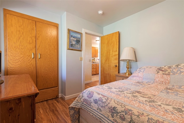 bedroom with dark wood-type flooring and a closet