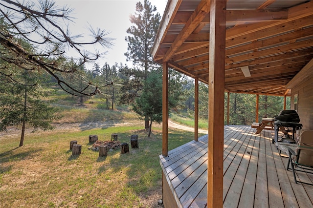 wooden deck featuring area for grilling and a yard