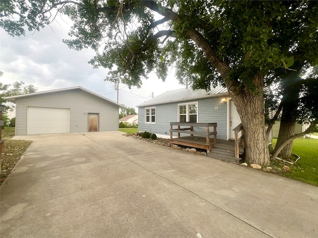 view of front facade featuring a deck, an outbuilding, a garage, and a front lawn