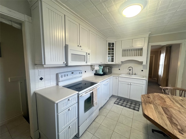 kitchen featuring white appliances, white cabinets, sink, backsplash, and ornamental molding