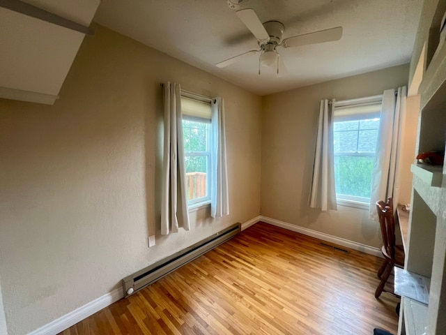 empty room with a baseboard radiator, light wood-type flooring, and ceiling fan