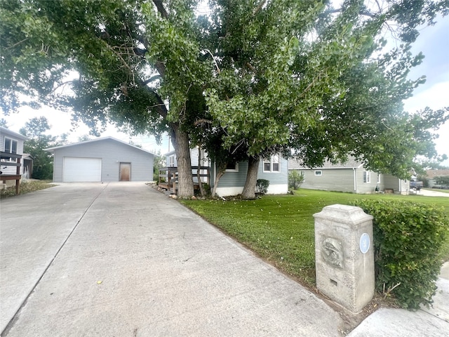 view of front of house with an outbuilding, a garage, and a front lawn