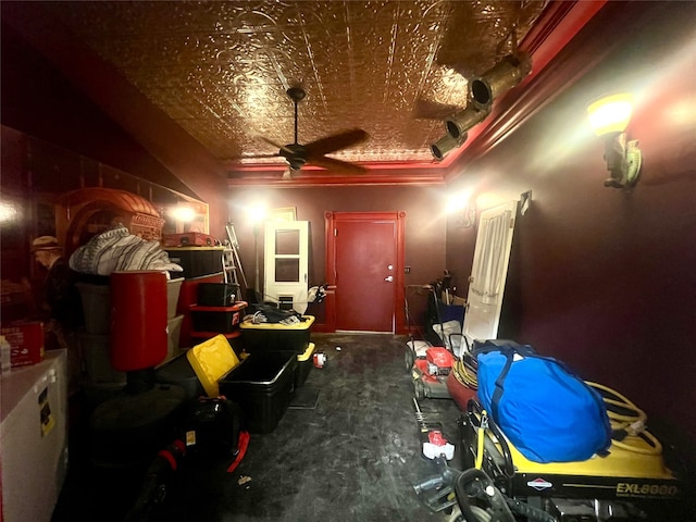 home theater room featuring ceiling fan and ornamental molding