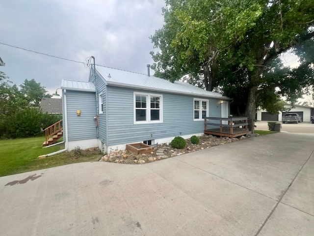 view of front facade with a deck and a front lawn