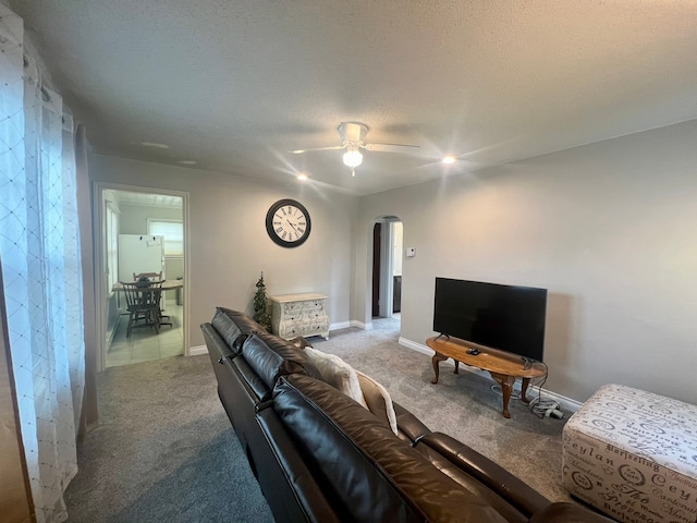 living room with carpet floors, a textured ceiling, and ceiling fan